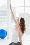 Fit woman stretching hand in fitness studio