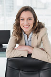 Elegant smiling businesswoman at office desk