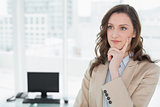 Thoughtful elegant smiling businesswoman in office