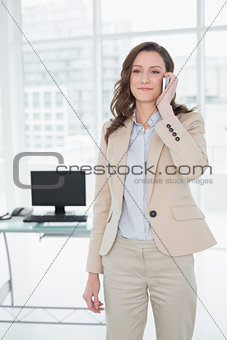 Elegant businesswoman using mobile phone in office