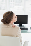 Businesswoman with neck pain in front of computer in office