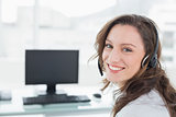 Businesswoman wearing headset in front of computer in office