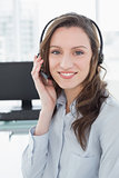 Portrait of businesswoman wearing headset in front of computer