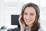 Portrait of businesswoman wearing headset in front of computer