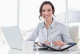 Elegant businesswoman with laptop and diary in office
