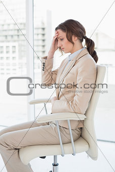 Side view of businesswoman suffering from headache in office
