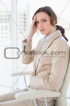 Portrait of businesswoman suffering from headache in office