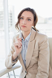 Thoughtful elegant businesswoman with pen in office
