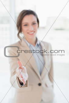 Elegant businesswoman offering a handshake in office