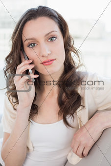 Portrait of a relaxed young woman using cellphone on sofa