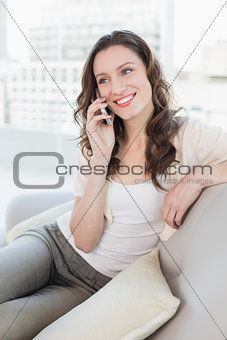 Relaxed young woman using cellphone on sofa