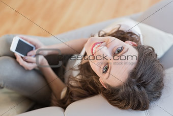 Overhead portrait of a woman with cellphone on sofa