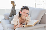 Portrait of casual woman reading a book on sofa