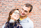 Portrait of love couple embracing looking happy against wall background