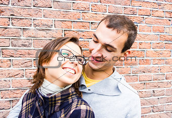 Portrait of love couple embracing looking happy against wall background