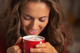 Smiling young woman in red dress having snack in christmas decor