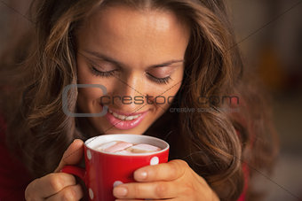 Smiling young woman in red dress having snack in christmas decor