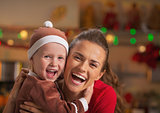 Portrait of smiling mother and baby in christmas decorated kitch
