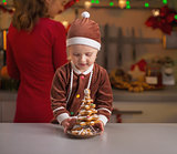 Baby helping mother making christmas preparations on kitchen