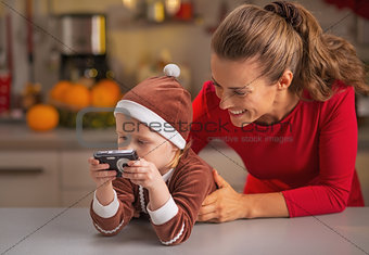 Happy mother and baby looking photos in camera