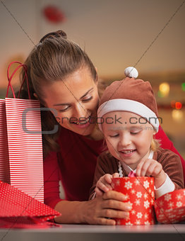 Happy mother and baby checking christmas purchases
