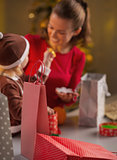 Closeup on christmas shopping bags and mother and baby in backgr
