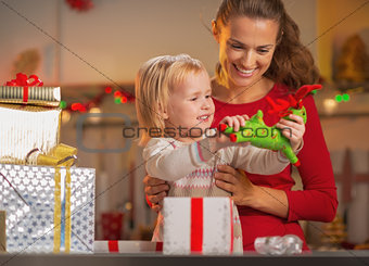 Happy mother and baby opening christmas presents