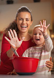Closeup on mother and baby hands smeared in flour