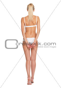 Full length portrait of young woman in lingerie . rear view