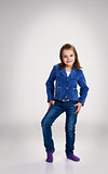 little girl in blue jeans and jacket posing in the studio