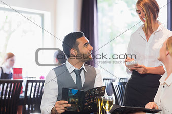 Handsome businessman ordering food from waitress