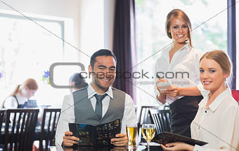 Business people and waitress smiling at camera