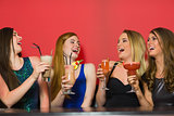 Laughing friends holding cocktails