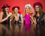 Laughing friends having hen party holding cocktails