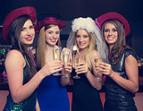 Attractive friends clinking champagne glasses at hen night