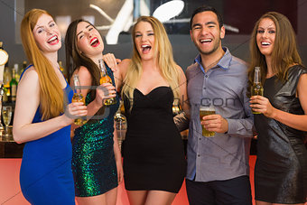Laughing friends holding beers posing