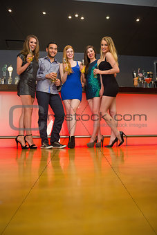 Attractive friends standing at a bar holding beer