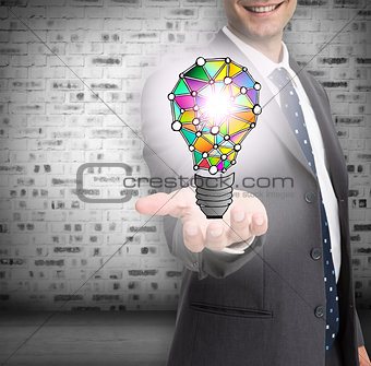 Close up of businessmans hand showing holographic light bulb