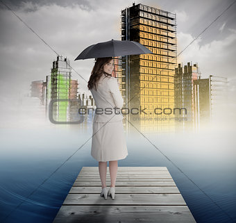Smiling businesswoman standing on bridge in front of colorful city