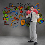 Businessman with boxing gloves standing in front of colored graphics