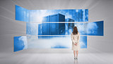 Rear view of businesswoman looking at futuristic server towers