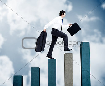 Young businessman climbing grey and blue steps