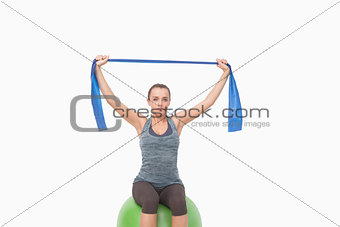 Young woman training sitting on a fitness ball
