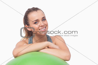 Sweet young woman supporting herself with a fitness ball