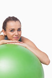 Cute sporty woman supporting herself with a fitness ball