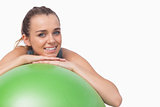 Sporty attractive woman supporting herself with a fitness ball