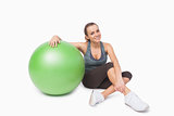 Cute woman sitting next to a fitness ball