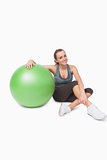 Sporty woman sitting next to a fitness ball