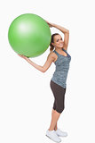Cheerful blonde woman holding a fitness ball