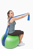 Cheerful woman stretching her arms using a resistance band